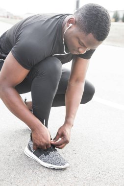 Spor ayakkabılarına ayakkabı bağlayan genç bir sporcu. Form, spor, egzersiz, egzersiz ve sağlıklı yaşam tarzı konsepti.