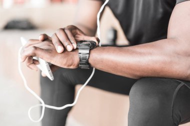 Genç erkek koşucu sporcu eğitim ve egzersiz açık havada şehirde yapıyor. bir egzersiz yaptıktan sonra dinlenme ve müzik ve bir spor izlerken bir zenci izle