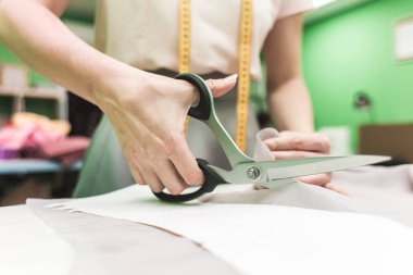 Dikiş atölyesi. Terzi iş başında. İşaretleme ve kesim kumaş.