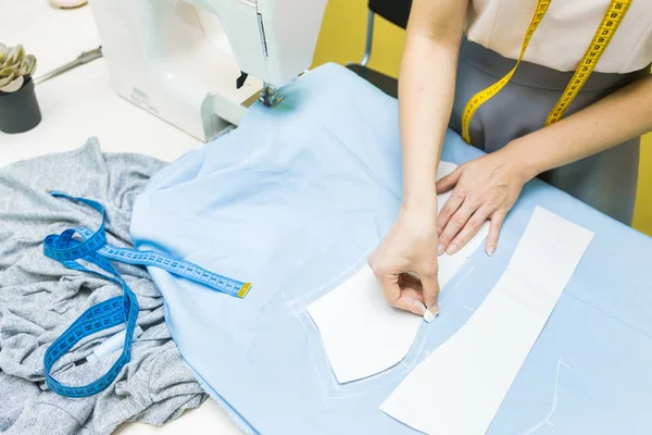 Nähwerkstatt. Näherin bei der Arbeit. Markieren und Schneiden von Gewebe. — Stockfoto