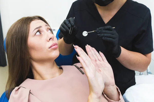 Clínica dentária. Recepção, exame do paciente. Cuidado com os dentes. Jovem sente medo no dentista — Fotografia de Stock