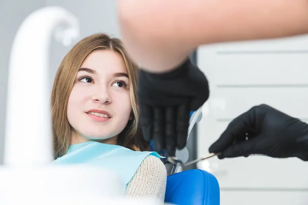 Clínica dental. Recepción, examen del paciente. Cuidado de los dientes. Dentista femenina en consultorio dental hablando con paciente chica . —  Fotos de Stock