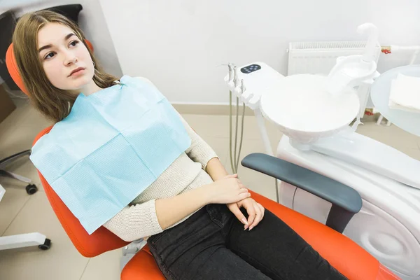 Clínica dental. Recepción, examen del paciente. Cuidado de los dientes. La chica está sentada en la silla dental lista para examinar los dientes. — Foto de Stock