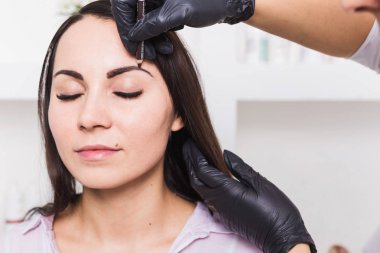 Kaşları güzellik salonu içinde güzel genç kadın için kalıcı makyaj