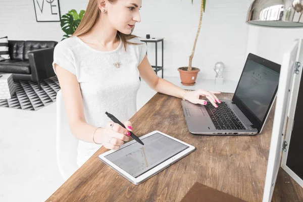 Joven mujer de negocios que trabaja en casa y se basa en la tableta. Espacio de trabajo de estilo escandinavo creativo — Foto de Stock