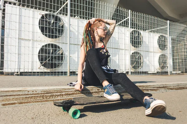 Chica joven con tatuaje y rastas en el fondo industrial urbano —  Fotos de Stock