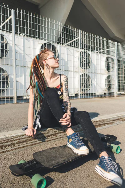 Chica joven con tatuaje y rastas en el fondo industrial urbano —  Fotos de Stock