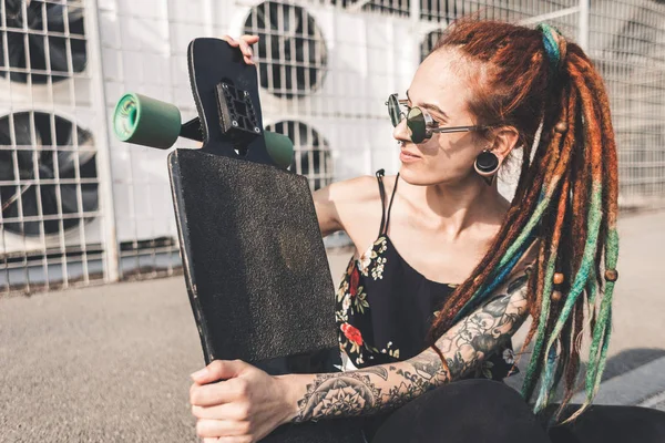 Young girl with tattoo and dreadlocks on urban industrial background — Stock Photo, Image