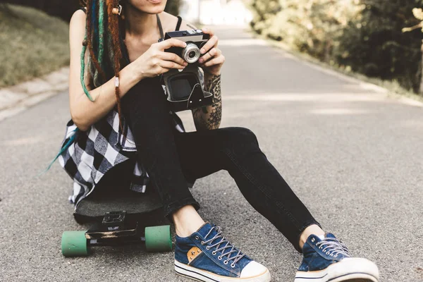 Jovem com tatuagens e dreadlocks fotografias câmera vintage no parque — Fotografia de Stock