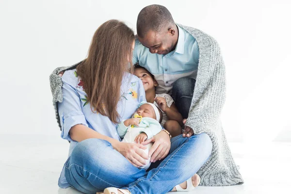 Loving father covers his family with a plaid. Happy multiethnic family. Family values