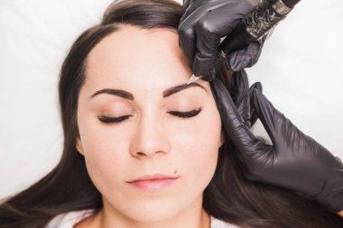 Kaşları güzellik salonu içinde güzel genç kadın için kalıcı makyaj