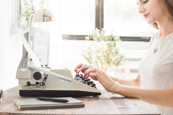 Joven mujer de negocios trabajando en casa y escribiendo en una máquina de escribir. Espacio de trabajo de estilo escandinavo creativo — Foto de Stock