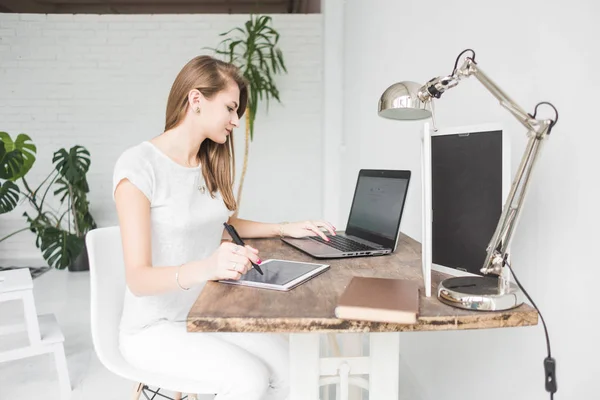 Joven mujer de negocios que trabaja en casa y se basa en la tableta. Espacio de trabajo de estilo escandinavo creativo — Foto de Stock