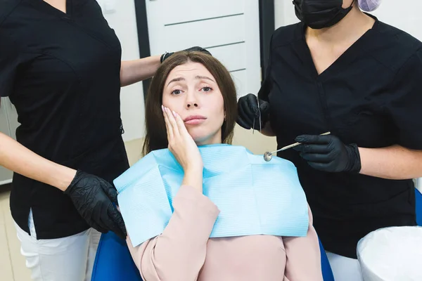 Clínica dental. Recepción, examen del paciente. Cuidado de los dientes. Mujer joven siente dolor en el dentista — Foto de Stock