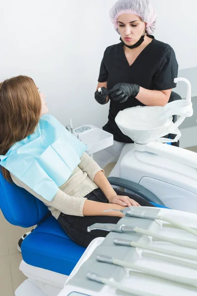 Dental clinic. Reception, examination of the patient. Teeth care. Female dentist in dental office talking with girl patient. — Stock Photo, Image