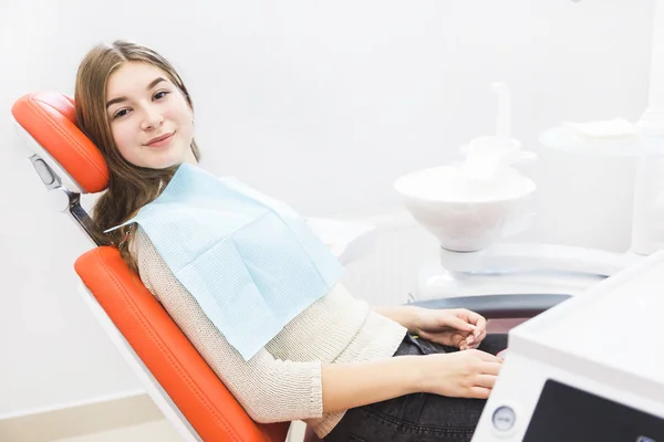 Dental clinic. Reception, examination of the patient. Teeth care. The girl is sitting in the dental chair ready to examine the teeth