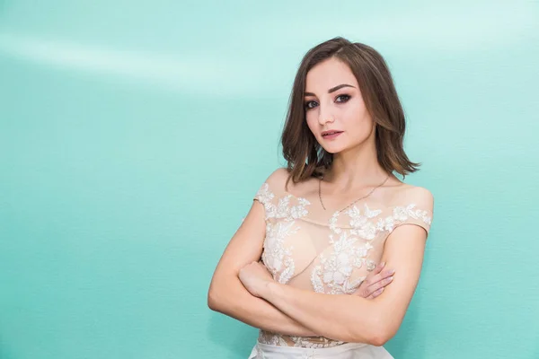 Mujer joven en un vestido de novia sobre un fondo de color . — Foto de Stock