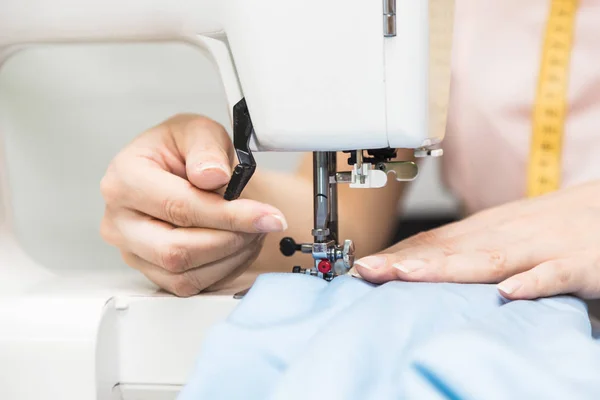 Nähwerkstatt. Näherin bei der Arbeit. junge Frau arbeitet mit Nähmaschine. — Stockfoto