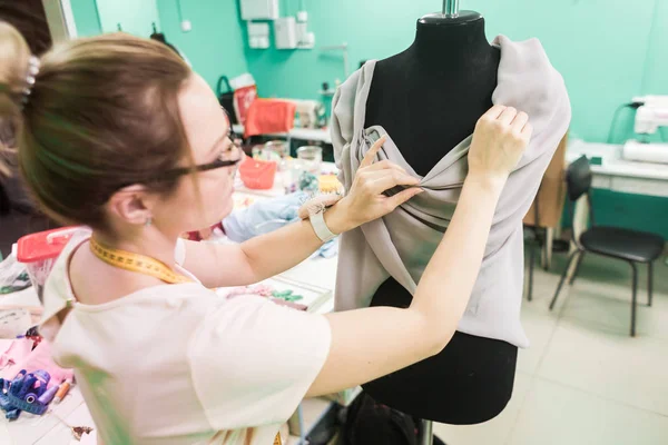 Workshop naaien. Naaister op het werk. Jonge naaister jurk op de studio bezig. — Stockfoto