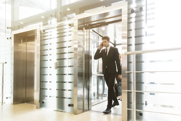 successful and young businessman in the elevator business center rides to work