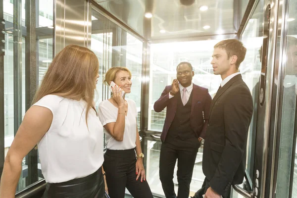 successful and young businessmen in the elevator business center rides to work