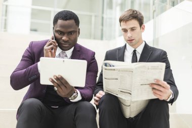 Olgun işadamı Genç bir meslektaşım bilgilerle bir modern iş salonda görüşmek üzere dijital tablet kullanma