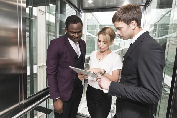 successful and young businessmen in the elevator business center rides to work