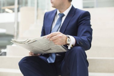 Bir gazete okuyan bir genç yakışıklı işadamı portresi