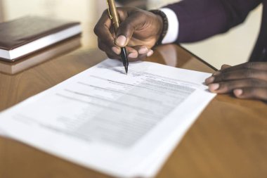 Afrikalı-Amerikalı dostum imza sözleşme, siyah adam el resmi belge üzerinde imza koyarak, biracial istemcilerin müşteriler çiftsiniz satınalma veya işareti prenuptial anlaşma kavramı. yukarı clouse