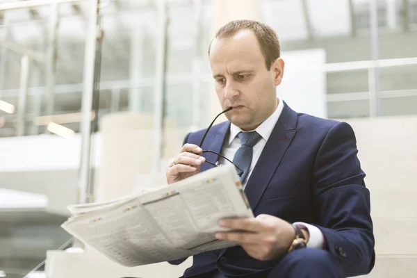 Retrato de un joven hombre de negocios guapo leyendo un periódico — Foto de Stock