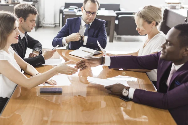 Jóvenes creativos multirraciales en la oficina moderna. Grupo de jóvenes empresarios están trabajando junto con el ordenador portátil, tableta, teléfono inteligente, portátil . — Foto de Stock