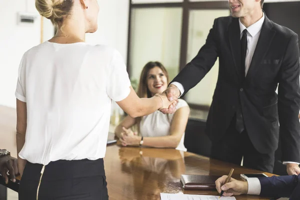 Jóvenes creativos multirraciales en la oficina moderna. Grupo de jóvenes empresarios están trabajando junto con el ordenador portátil, tableta, teléfono inteligente, portátil. apretón de manos — Foto de Stock