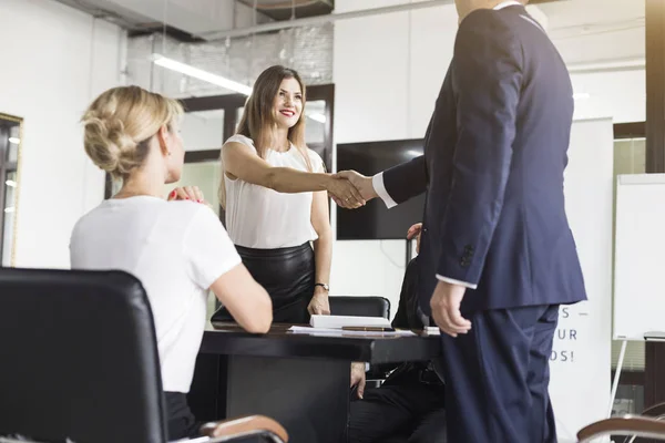 Jóvenes creativos multirraciales en la oficina moderna. Grupo de jóvenes empresarios están trabajando junto con el ordenador portátil, tableta, teléfono inteligente, portátil. apretón de manos — Foto de Stock