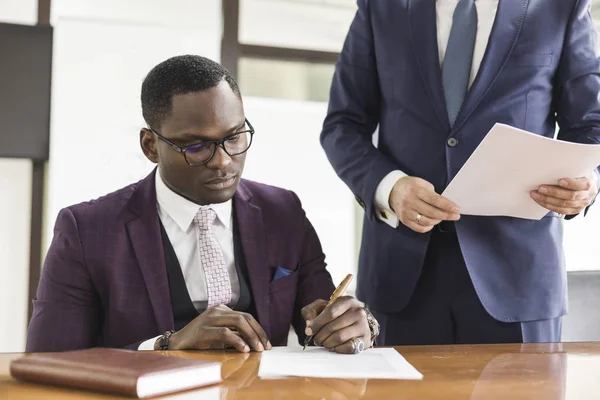 Contrato de firma de hombre afroamericano, mano de hombre negro poniendo firma en documento oficial, clientes biraciales pareja hacen compra o firman concepto de acuerdo prenupcial — Foto de Stock