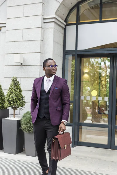 stylish businesswoman with briefcase on city background. African American man talking on mobile phone