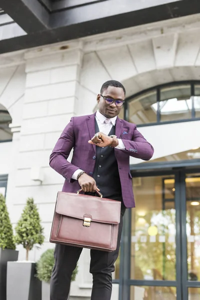 stylish businesswoman with briefcase on city background. African American man talking on mobile phone