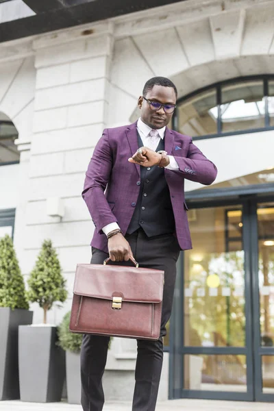 stylish businesswoman with briefcase on city background. African American man talking on mobile phone