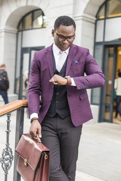 stylish businesswoman with briefcase on city background. African American man talking on mobile phone