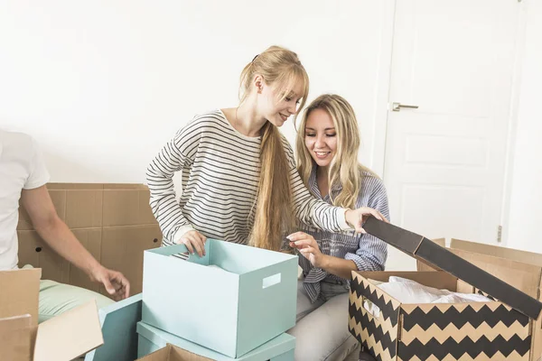 Famiglia disfare scatole di cartone in una nuova casa. trasferirsi in una nuova casa. concetto di una famiglia felice e housewarming — Foto Stock