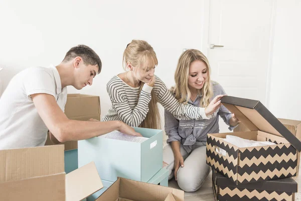 Familjen uppackning pappkartonger på nya hem. flytta till ett nytt hus. begreppet en lycklig familj och inflyttningsfest — Stockfoto