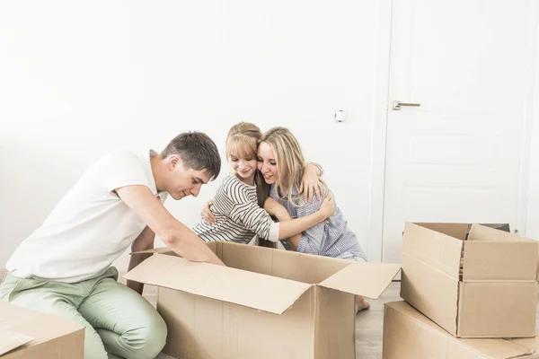 Famiglia disfare scatole di cartone in una nuova casa. trasferirsi in una nuova casa. concetto di una famiglia felice e housewarming — Foto Stock