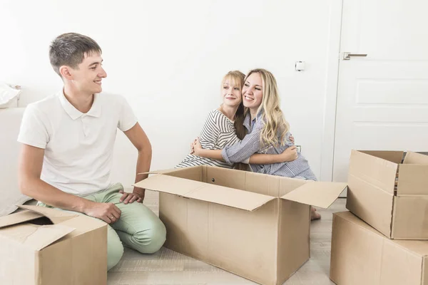 Familia desembalaje cajas de cartón en el nuevo hogar. mudarse a una casa nueva. concepto de una familia feliz y la inauguración de la casa — Foto de Stock