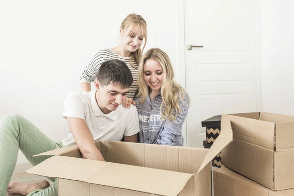 Familia desembalaje cajas de cartón en el nuevo hogar. mudarse a una casa nueva. concepto de una familia feliz y la inauguración de la casa — Foto de Stock