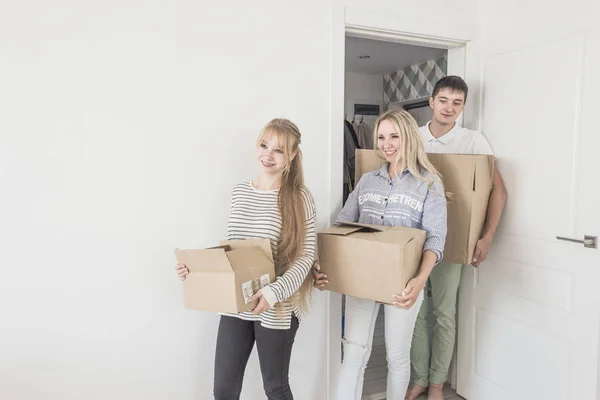 Familia desembalaje cajas de cartón en el nuevo hogar. mudarse a una casa nueva. concepto de una familia feliz y la inauguración de la casa — Foto de Stock