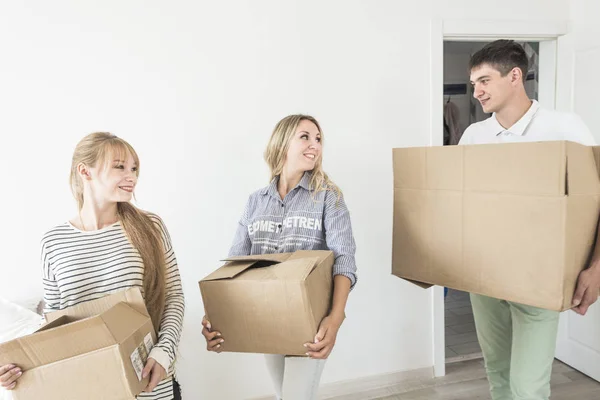 Famiglia disfare scatole di cartone in una nuova casa. trasferirsi in una nuova casa. concetto di una famiglia felice e housewarming — Foto Stock