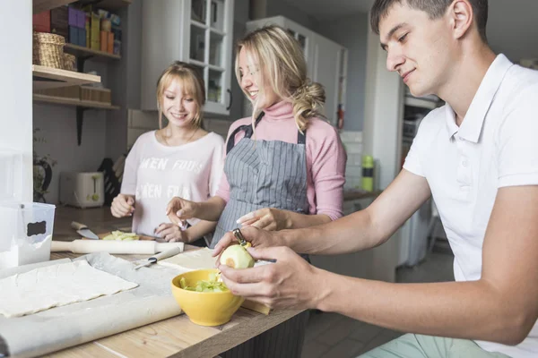 Familia feliz está preparando un pastel en la cocina en casa. concepto de familia feliz y acogedor hogar — Foto de Stock
