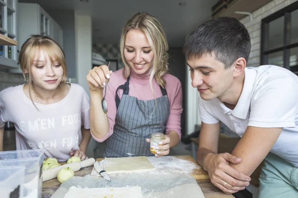 Família feliz está preparando uma torta na cozinha em casa. conceito de família feliz e aconchego em casa — Fotografia de Stock