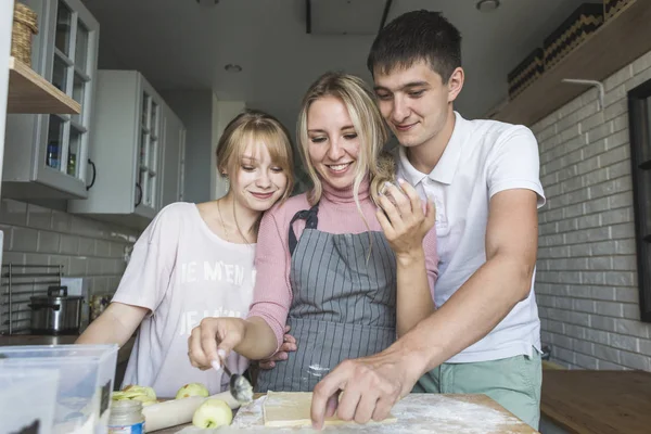 Familia feliz está preparando un pastel en la cocina en casa. concepto de familia feliz y acogedor hogar — Foto de Stock