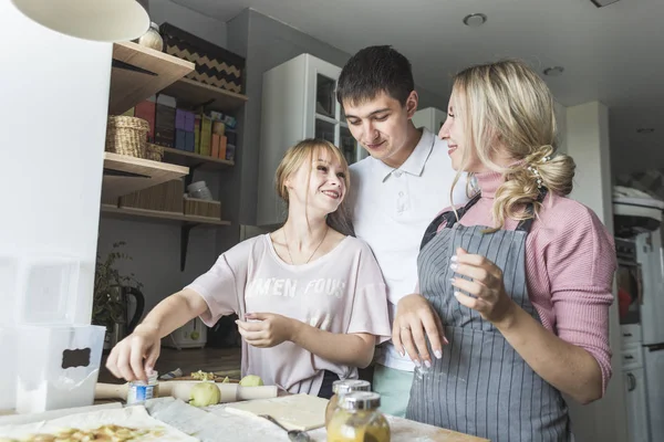 Família feliz está preparando uma torta na cozinha em casa. conceito de família feliz e aconchego em casa — Fotografia de Stock