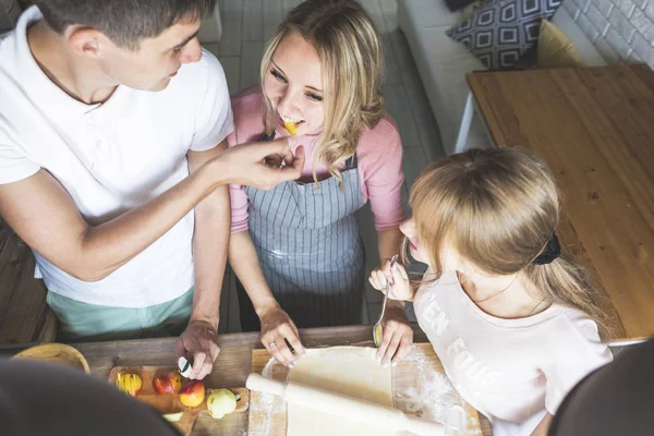 幸福的家庭正在家里的厨房里准备一个馅饼。幸福家庭和家庭舒适的概念 — 图库照片